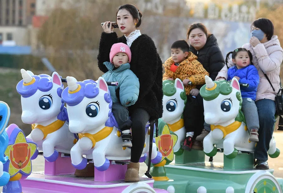 This photo taken on 16 January 2025 shows children taking a ride with adults in a park in Fuyang, east China’s Anhui province. (AFP)