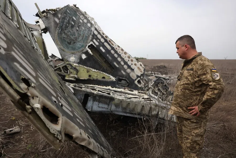 A Ukrainian pilot examines the remains of his SU-24M aircraft on the outskirts of the town of Izyum, Kharkiv region, on 17 April 2024, amid the Russian invasion in Ukraine. (Anatolii Stepanov/AFP)