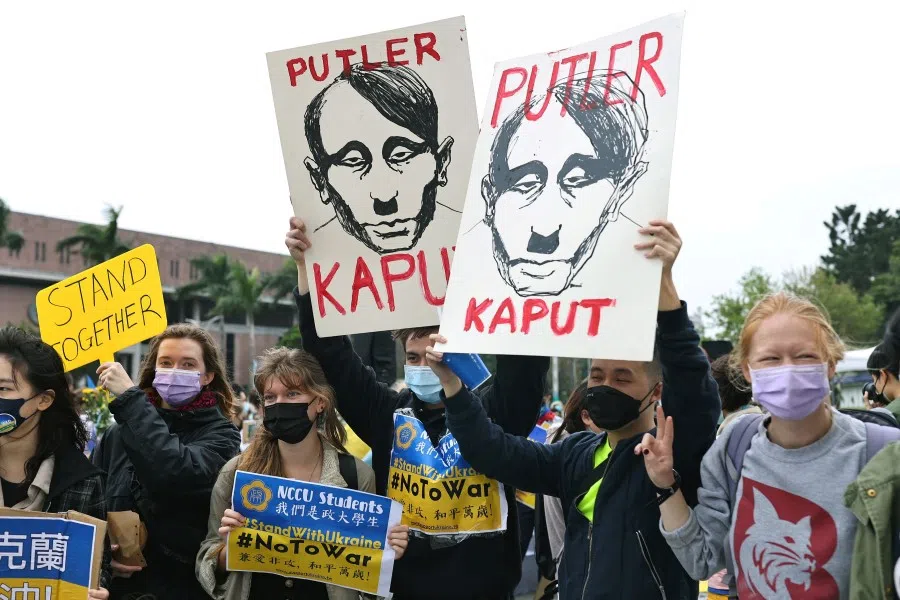 People hold signs as they attend a rally against Russia's invasion of Ukraine in Taipei, Taiwan, 6 March 2022. (Ann Wang/Reuters)