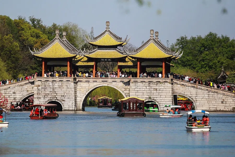 This photo taken on 4 April 2021 shows people visiting the Slender West Lake in Yangzhou, Jiangsu province, China. (STR/AFP)