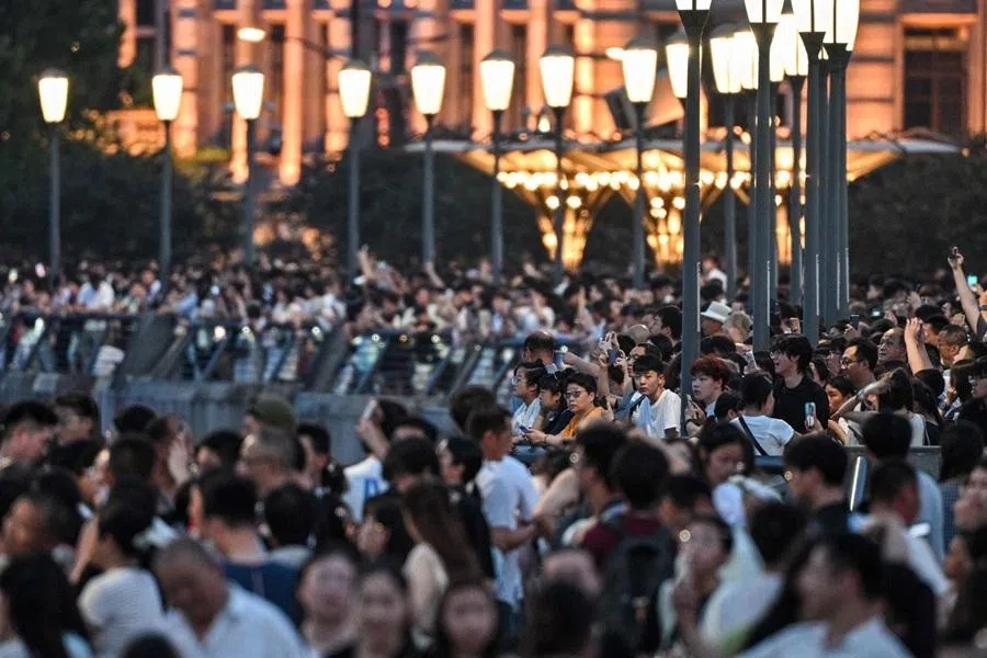 People visit the Bund promenade along the Huangpu river in Shanghai on 17 July 2026.