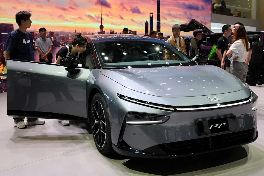 People look at a XPeng P7+ electric vehicle (EV) during a media day for the Auto Shanghai show in Shanghai, China, on 23 April 2025. New energy vehicle companies like XPeng enjoy higher trading volumes on the Hong Kong exchange. (Go Nakamura/Reuters)