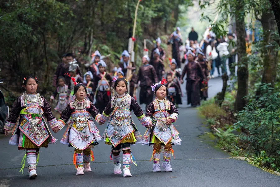 This photo taken on 2 December 2023 shows children of the Miao ethnic minority dressed in traditional costumes taking part in the Lusheng festival in Congjiang in China's southwestern Guizhou province. (AFP)
