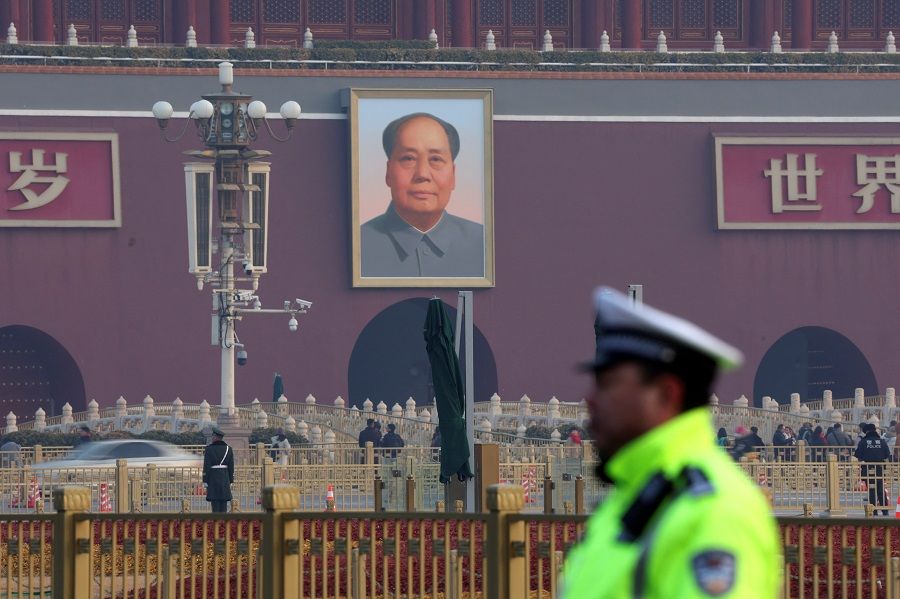 A police officer keeps watch in front of a portrait of the late Chinese chairman Mao Zedong on the Tiananmen Gate, near the Great Hall of the People in Beijing, China, on 7 March 2024. (Florence Lo/Reuters)