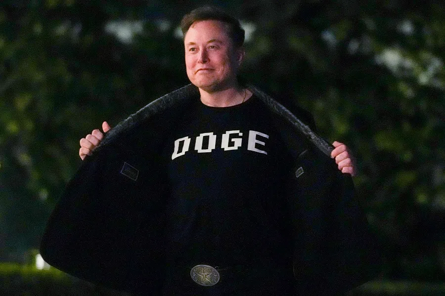 Elon Musk shows off a shirt that says “DOGE” as he walks on the South Lawn of the white House after stepping off Marine One upon arrival at the White House in Washington, DC, on 9 March 2025. (Oliver Contreras/AFP)
