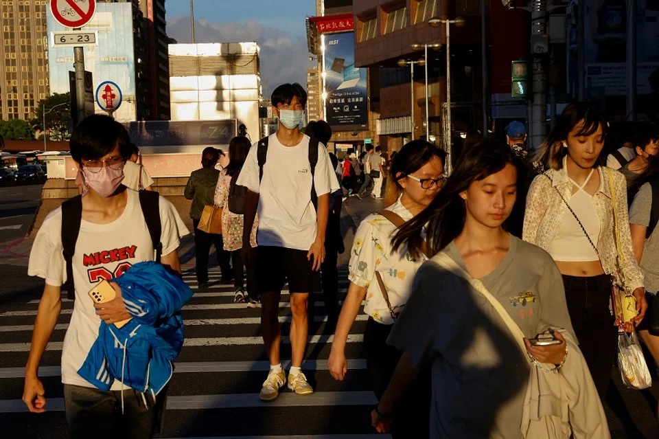 People walk on the street in Taipei, Taiwan, on 25 July 2023. (Ann Wang/Reuters)