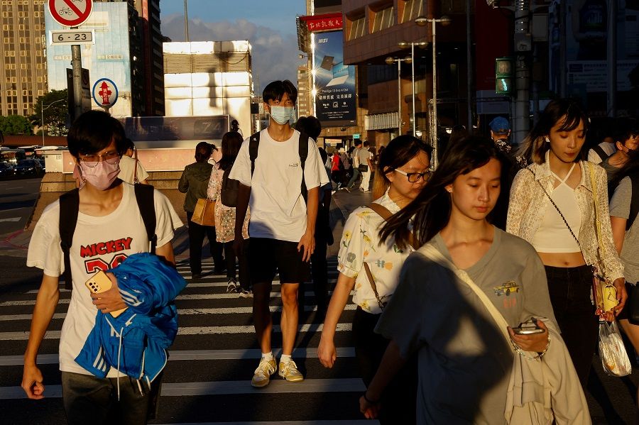 People walk on the street in Taipei, Taiwan, 25 July 2023. (Ann Wang/Reuters)