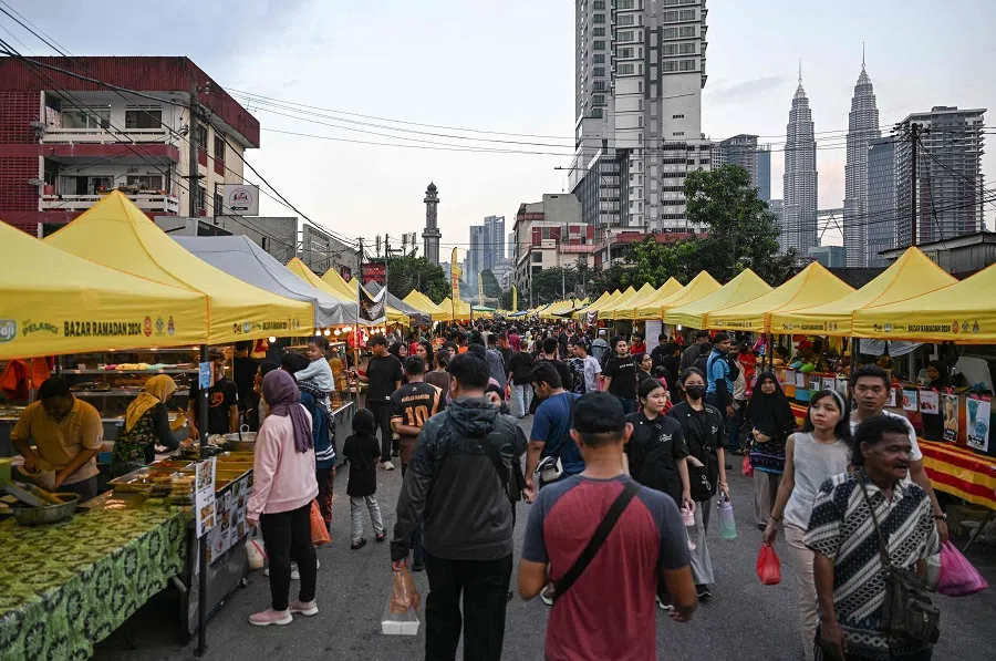 Muslim devotees walk in a street market as they buy food before breaking their fast during the Islamic holy fasting month of Ramadan in Kampung Baru neighbourhood of Kuala Lumpur on 18 March 2024. (Mohd Rasfan/AFP)