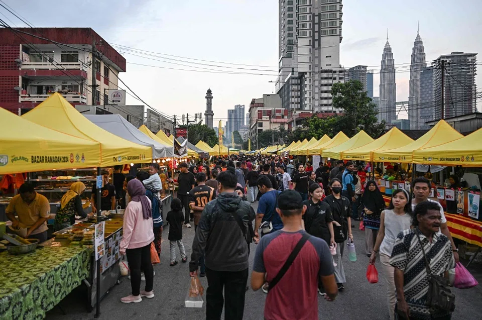 Muslim devotees walk in a street market as they buy food before breaking their fast during the Islamic holy fasting month of Ramadan in Kampung Baru neighbourhood of Kuala Lumpur on 18 March 2024. (Mohd Rasfan/AFP)