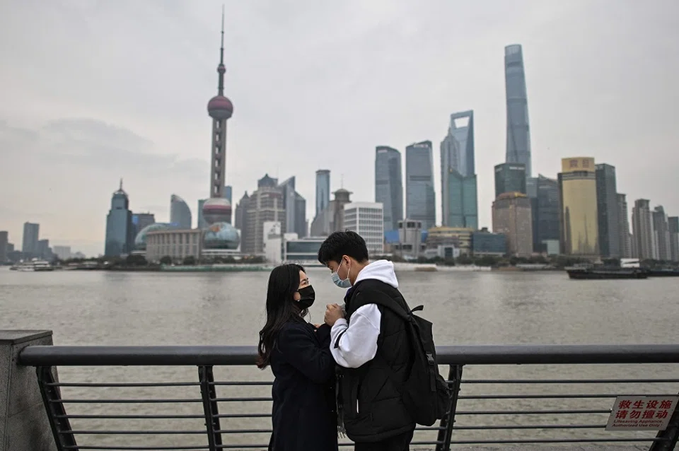 In this photo taken on 5 March 2021, a couple visits the promenade on the Bund along Huangpu River in Shanghai, China. (Hector Retamal/AFP)