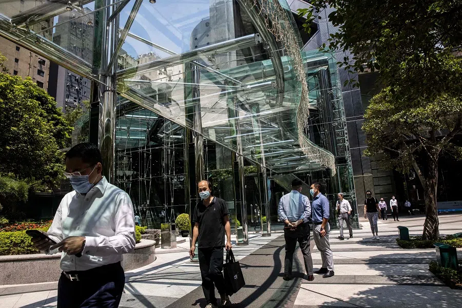 People walk outside a commercial office building in the Central district of Hong Kong, China, on 15 September 2022. (Isaac Lawrence/AFP)