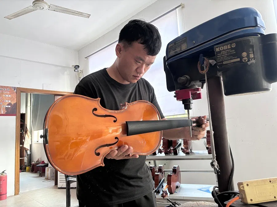 Peng Xuanyu works on a violin.