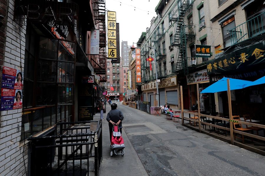 A woman walks down a nearly empty Pell Street in Manhattan's Chinatown district in New York City, US, 2 June 2021. (Mike Segar/Reuters)