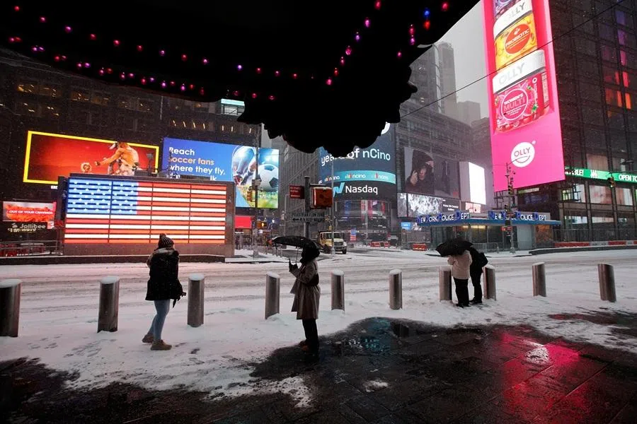People during snowfall around Times Square, as a major winter storm spread across a large swath of the US, in New York City, US, on 25 January 2026. (Eduardo Munoz/Reuters)