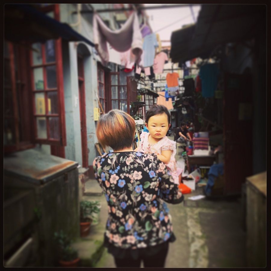 A mother and her little one walking through a typical lilong.