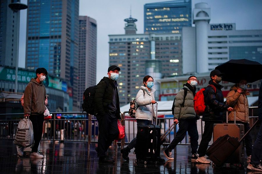 People wearing protective masks walk at the Shanghai Railway Station, as the annual Spring Festival travel rush begins ahead of the Chinese New Year in Shanghai, China, 27 January 2022. (Aly Song/Reuters)