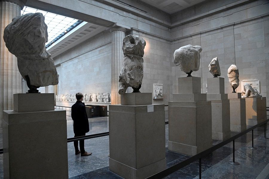 An employee poses as he views examples of the Parthenon sculptures on display at the British Museum in London, Britain, on 25 January 2023. (Toby Melville/Reuters)