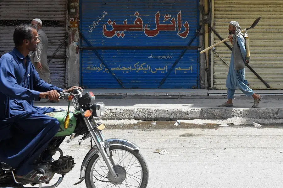 Commuters make their way through a closed market area during a nationwide strike called by trade organisations against the high electricity bills, excessive taxes and the absence of business-friendly policies, in Quetta on 28 August 2024. (Banaras Khan/AFP)