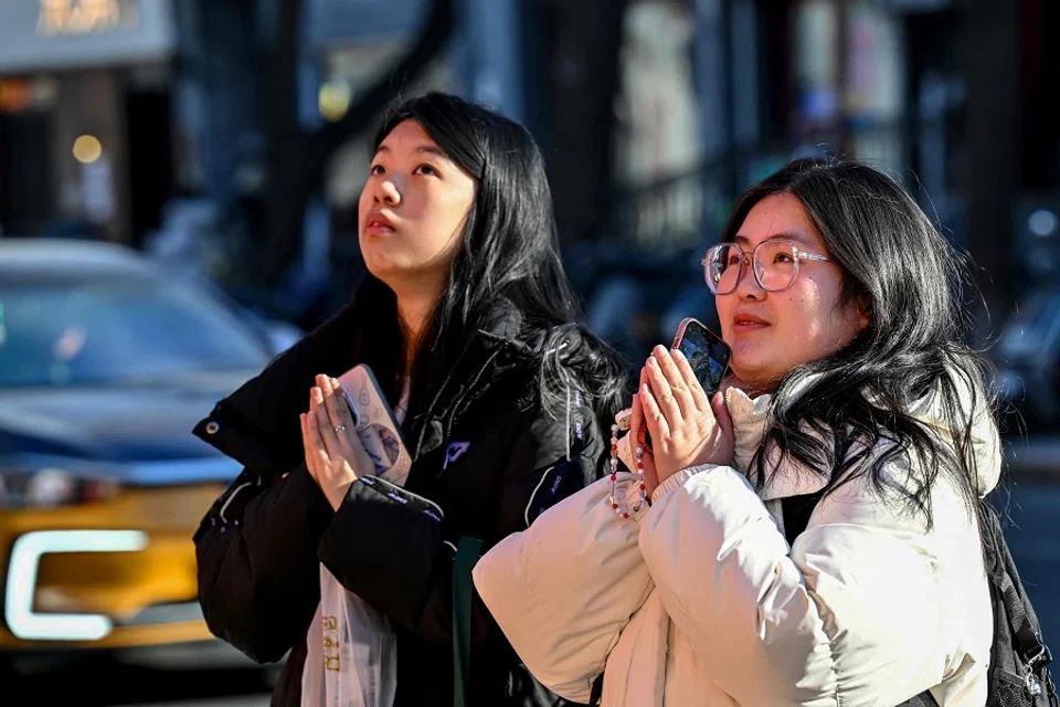Women offer prayers outside a temple next to the Nanluoguxiang alleyway in Beijing on 6 January 2025. (Adek Berry/AFP)