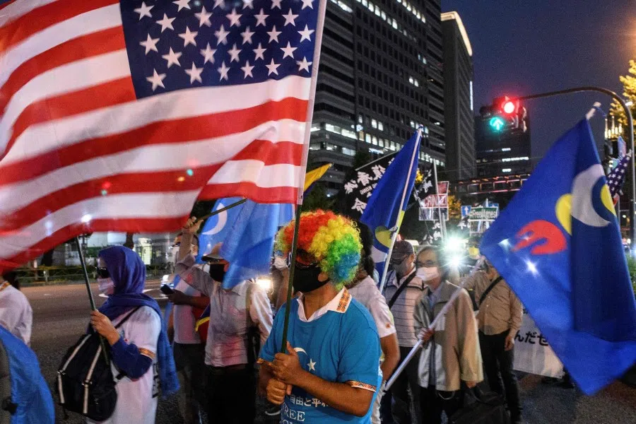 An activist waves the US flag during an anti-China protest to mark the 71st anniversary of the founding of the People's Republic of China in Shinjuku district of Tokyo on 3 October 2020. (Philip Fong/AFP)