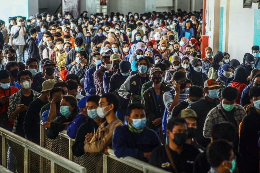 People wearing protective face masks stand in line to receive a dose of a coronavirus disease (COVID-19) vaccine, during a mass vaccination program in Bogor, on the outskirts of Jakarta, Indonesia, 19 August 2021. (Yulius Satria Wijaya/via Reuters)