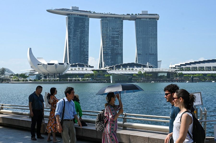 People walk along the Marina Bay waterfront in Singapore, 25 May 2023. (Roslan Rahman/AFP)