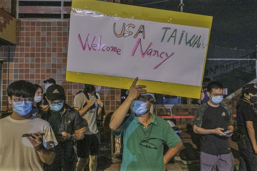 Supporters outside Songshan Airport as US House Speaker Nancy Pelosi arrives in Taipei, Taiwan, on 2 August 2022. (Lam Yik Fei/Bloomberg)