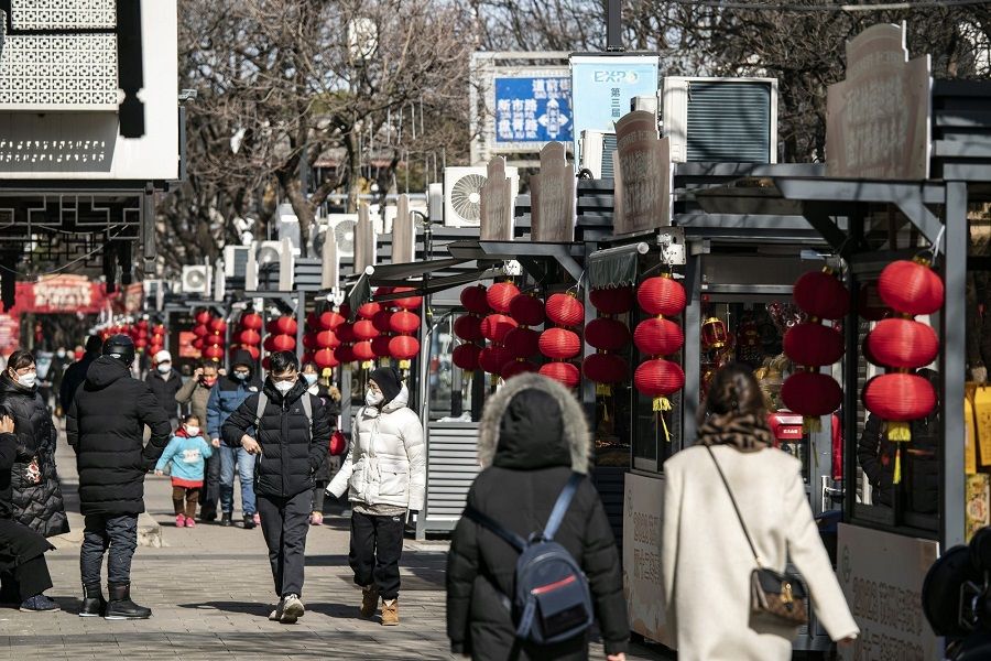 People walk on a street in Suzhou, Jiangsu province, China, on 25 January 2023. (Qilai Shen/Bloomberg)