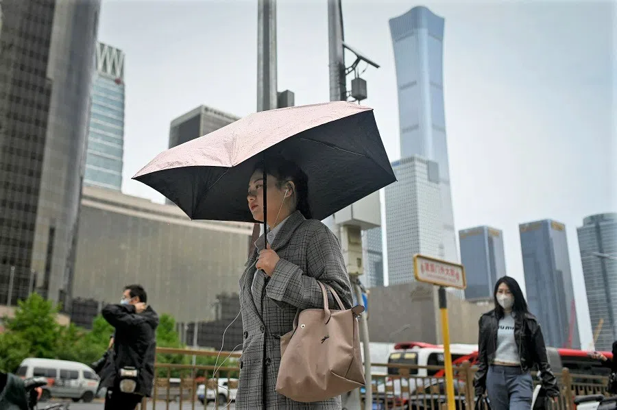 People walk on a street in Beijing, China, on 5 May 2023. (Wang Zhao/AFP)
