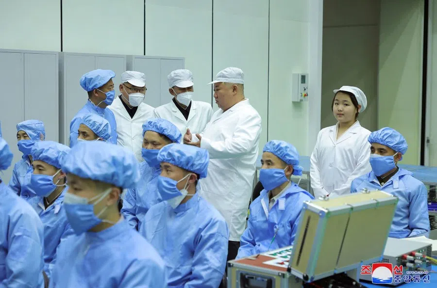 This picture taken on 16 May 2023 and released by North Korea's official Korean Central News Agency (KCNA) on 17 May 2023 shows North Korean leader Kim Jong-un (centre) and his daughter, presumed to be named Ju Ae (second from right), meeting with the Non-Permanent Satellite Launch Preparatory Committee and inspecting a military reconnaissance satellite, at an undisclosed location in North Korea. (KCNA via KNS/AFP)