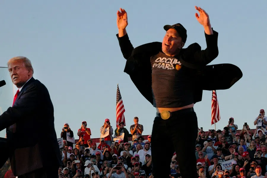 Tesla CEO and X owner Elon Musk reacts next to Republican presidential nominee and former US president Donald Trump during a campaign rally, at the site of the July assassination attempt against Trump, in Butler, Pennsylvania, US, on 5 October 2024.