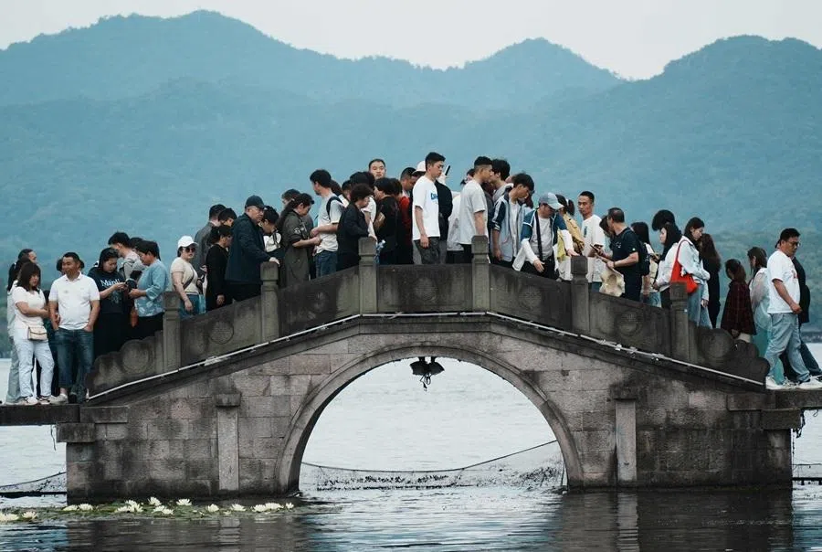 People crowd a bridge over West Lake in Hangzhou, in Chinas eastern Zhejiang province on 3 May 2026, during a five-day national May Day holiday.