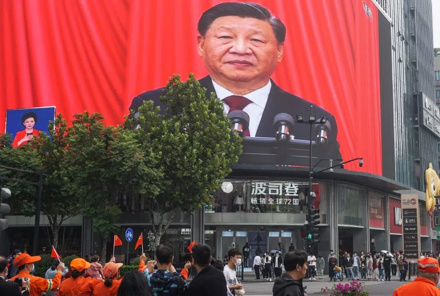 People watch an outdoor screen showing the live speech of Chinese President Xi Jinping during the opening session of the 20th Chinese Communist Party Congress in Hangzhou, Zhejiang province, China, on 16 October 2022. (AFP)