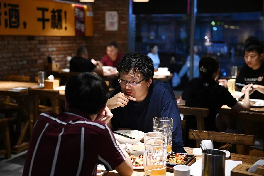 People eat in a restaurant in Beijing, China, on 26 August 2023. (Greg Baker/AFP)