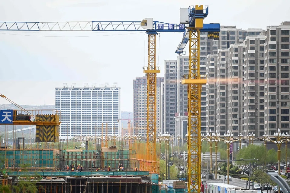 This picture shows workers on a construction site in Shenmu, Shaanxi province, China, on 24 April 2023. (Wang Zhao/AFP)