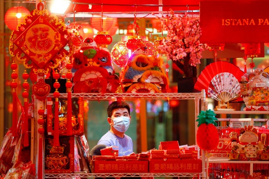 A man wearing a protective mask shops for decorations at a shopping mall ahead of the Lunar New Year, in Jakarta, Indonesia, 11 February 2021. (Ajeng Dinar Ulfiana/Reuters)