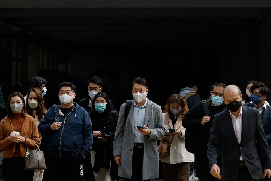 People wear face masks on a street in Hong Kong, China, 28 February 2023. (Tyrone Siu/Reuters)