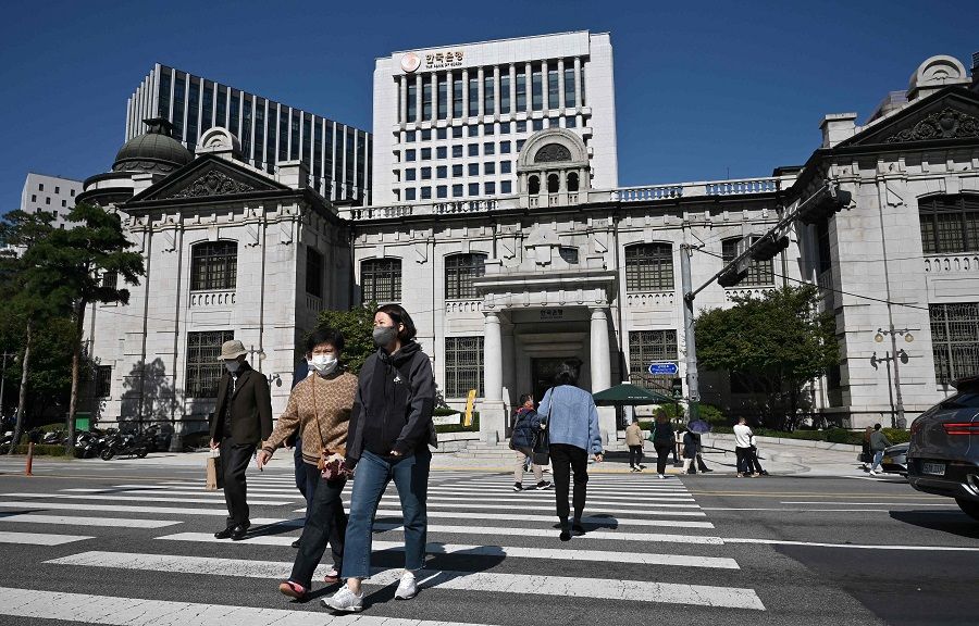 Pedestrians cross a road in front of the Bank of Korea headquarters in Seoul, South Korea, on 12 October 2022. (Jung Yeon-je/AFP)