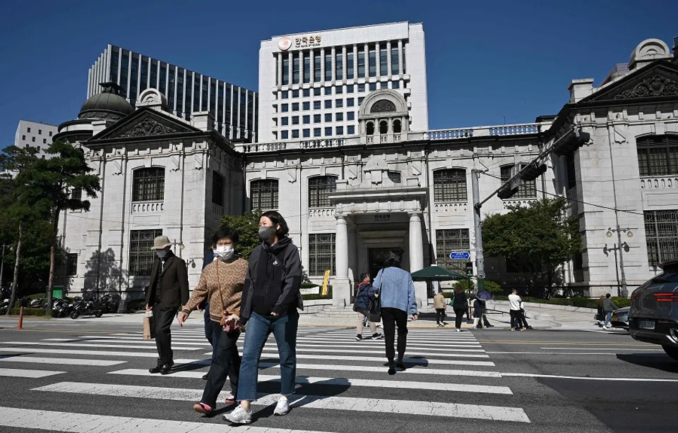 Pedestrians cross a road in front of the Bank of Korea headquarters in Seoul, South Korea, on 12 October 2022. (Jung Yeon-je/AFP)