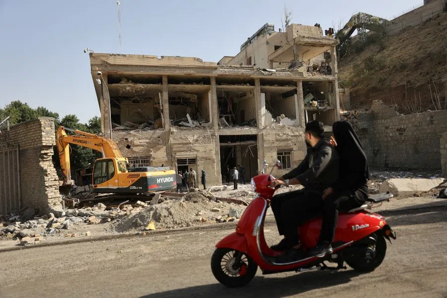 People ride on a motorcycle as a view shows the aftermath of an Israeli strike on Evin Prison that took place on 23 June, after the ceasefire between Israel and Iran, in Tehran, Iran, on 29 June 2025.