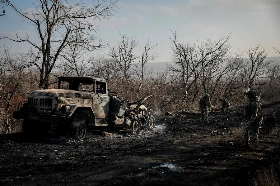 This handout photograph taken on 10 January 2025 and released by the press service of the 24th Mechanized Brigade of Ukrainian Armed Forces on 13 January 2025 shows servicemen of engineer supply group of 24th Mechanized Brigade checking a road next to a burned military vehicle near Chasiv Yar town, in the Donetsk region, Ukraine. (Handout/24th Mechanized Brigade of Ukrainian Armed Forces/AFP)