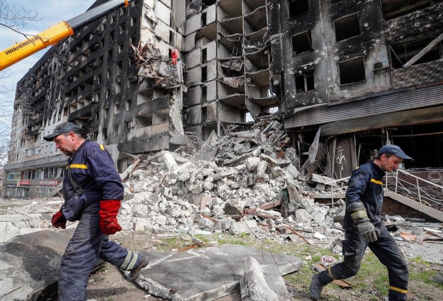 Emergency workers remove debris of a building destroyed in the course of the Ukraine-Russia conflict, in the southern port city of Mariupol, Ukraine, 10 April 2022. (Alexander Ermochenko/Reuters)