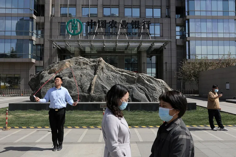 People are seen in front of an office building of Agricultural Bank of China, in Beijing, China on 29 March 2021.