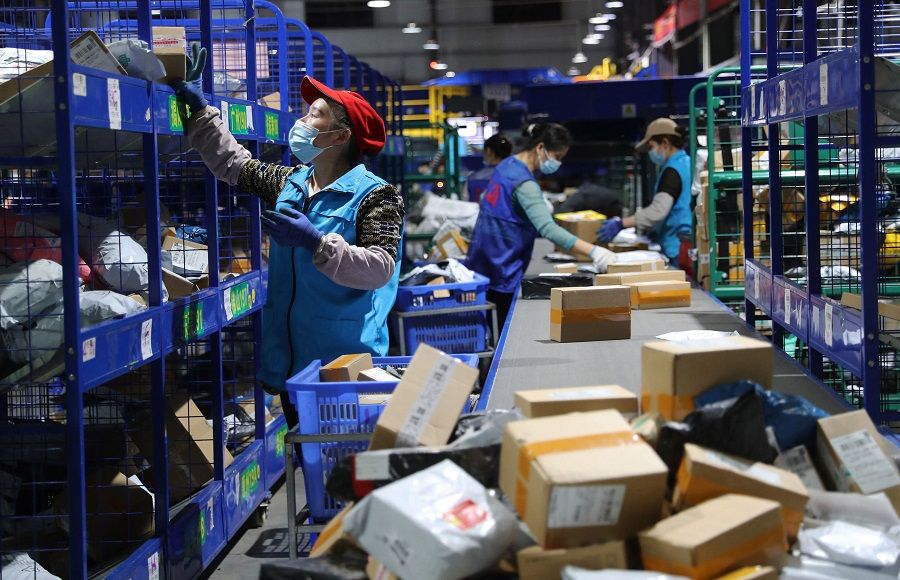 This photo taken on 12 November 2022 shows employees sorting packages for delivery after the Singles' Day shopping festival at a logistics centre in Hengyang, Hunan province, China. (AFP)