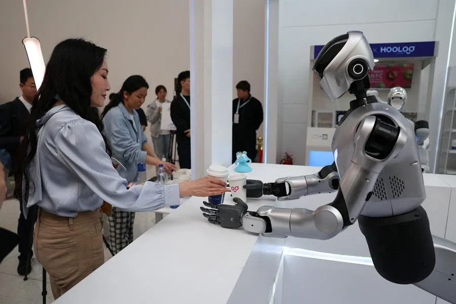 A Kuavo-5W humanoid robot by Leju Robotics passes freshly made coffee to a journalist during a demonstration simulating a cafe, at the 2026 Zhongguancun forum, in Beijing, China, on 25 March 2026.