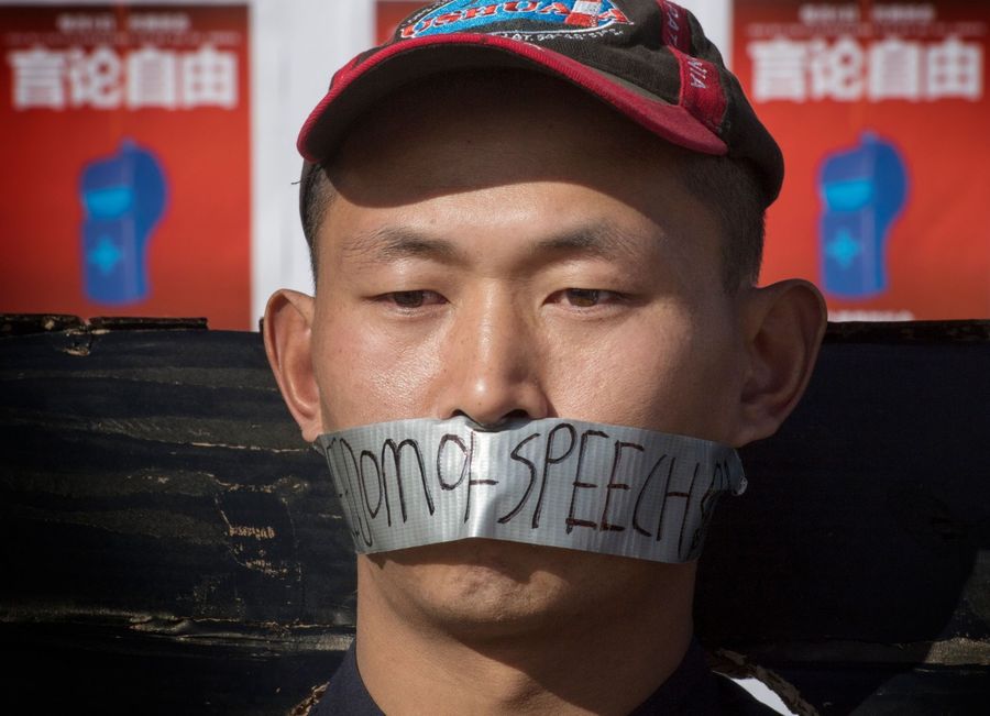 Chinese students hold a memorial for Dr Li Wenliang outside the UCLA campus in Westwood, California, on 15 February 2020. In the photo, the student has the words "freedom of speech" written on the duct tape over his mouth. (Mark Ralston/AFP)