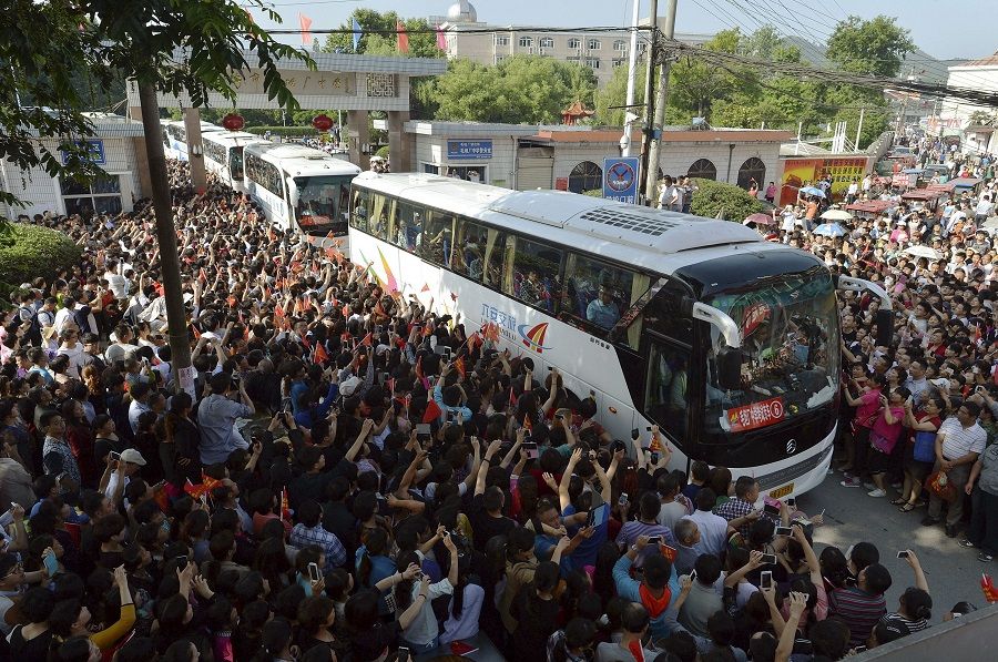 People see off buses carrying students who are travelling to attend the college entrance examination, or gaokao, at Maotanchang Middle School in Liu'an, Anhui province, China, 5 June 2015. (Stringer/Reuters)