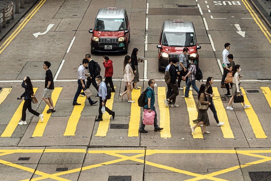 Pedestrians cross a road in Hong Kong, China, on 24 April 2023. (Lam Yik/Bloomberg)