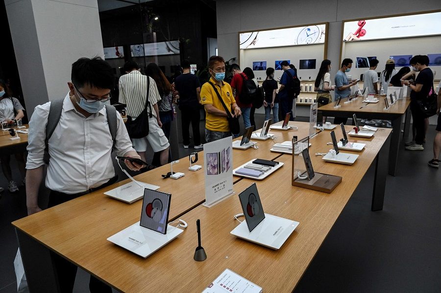 This photo taken on 8 July 2022 shows people trying Huawei products at the company's flagship store in Shenzhen, Guangdong province, China. (Jade Gao/AFP)