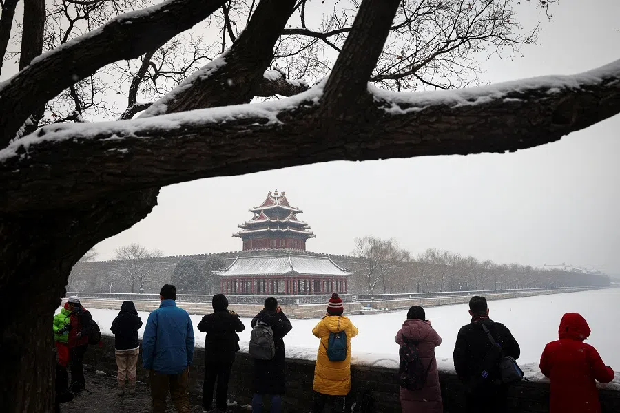 People take pictures of the Forbidden City after an overnight snowfall in Beijing, China, 22 January 2022. (Thomas Peter/Reuters)